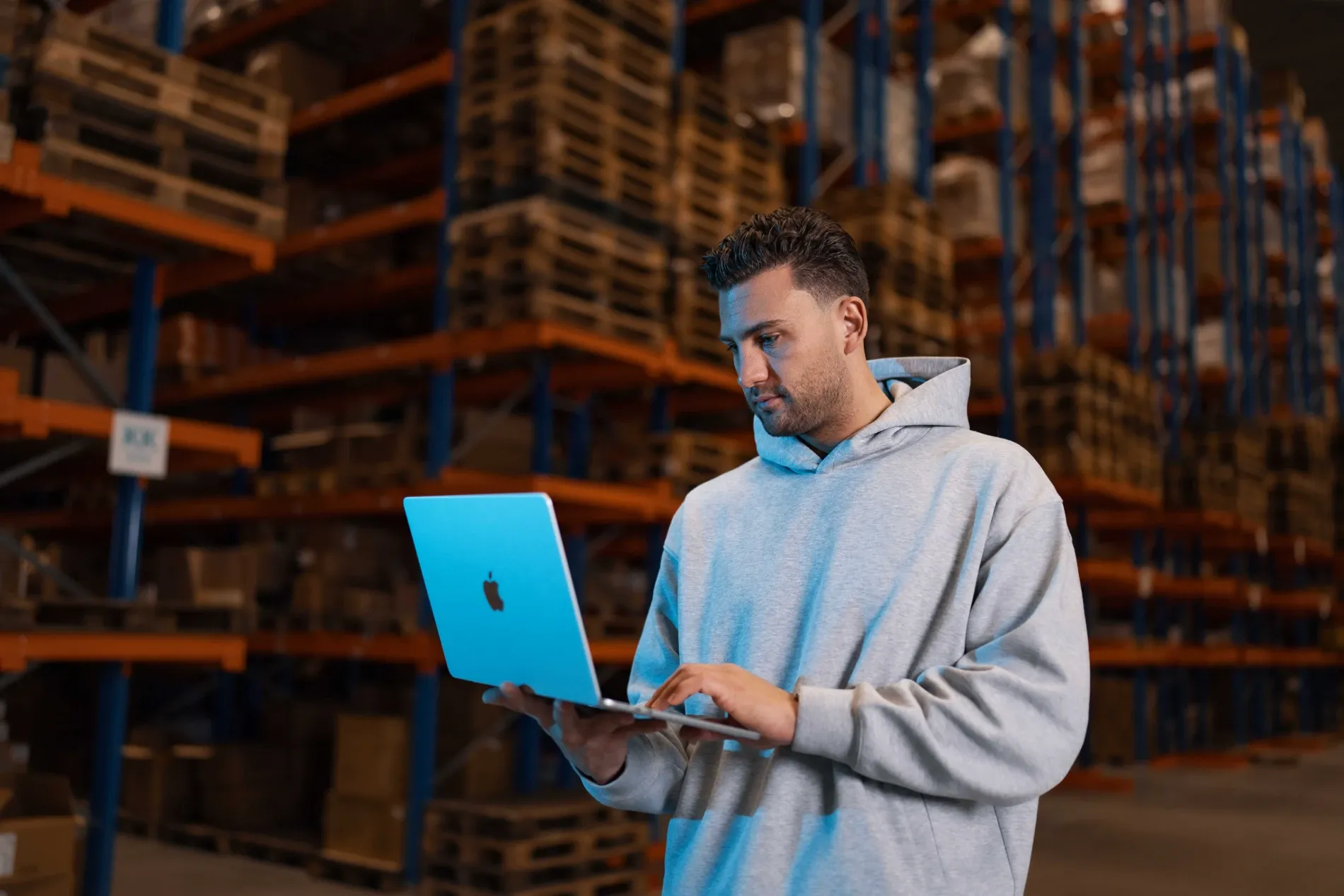 Specialist van Klubb met een laptop tussen de stellingen van een webshop