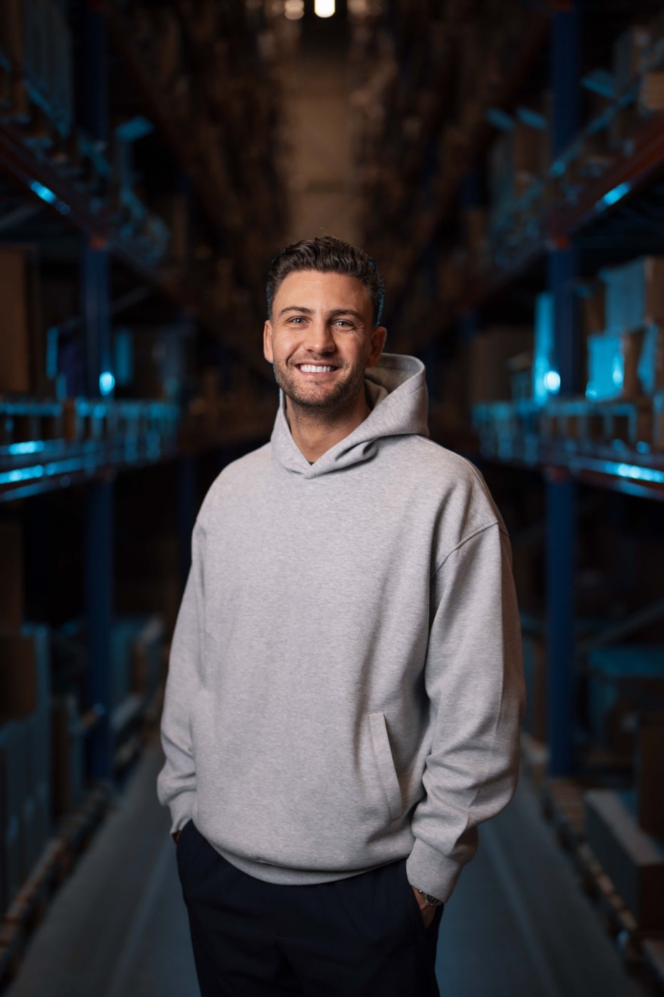 Portret van Daan van den Nosterum tussen de stellingen van een magazijn