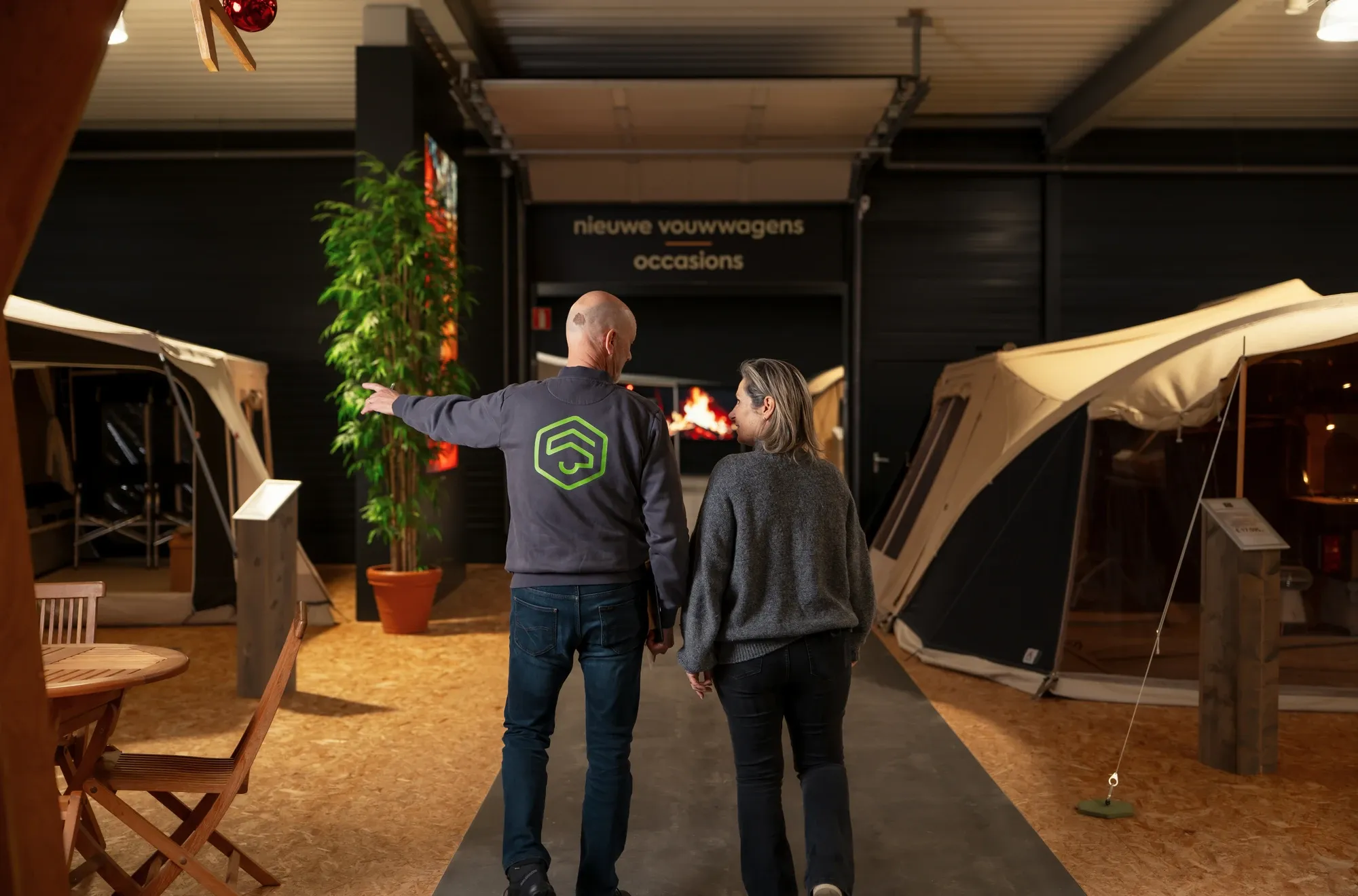 Medewerker van De Vouwwagenspecialist wijst een klant de weg langs de vouwwagens in de showroom