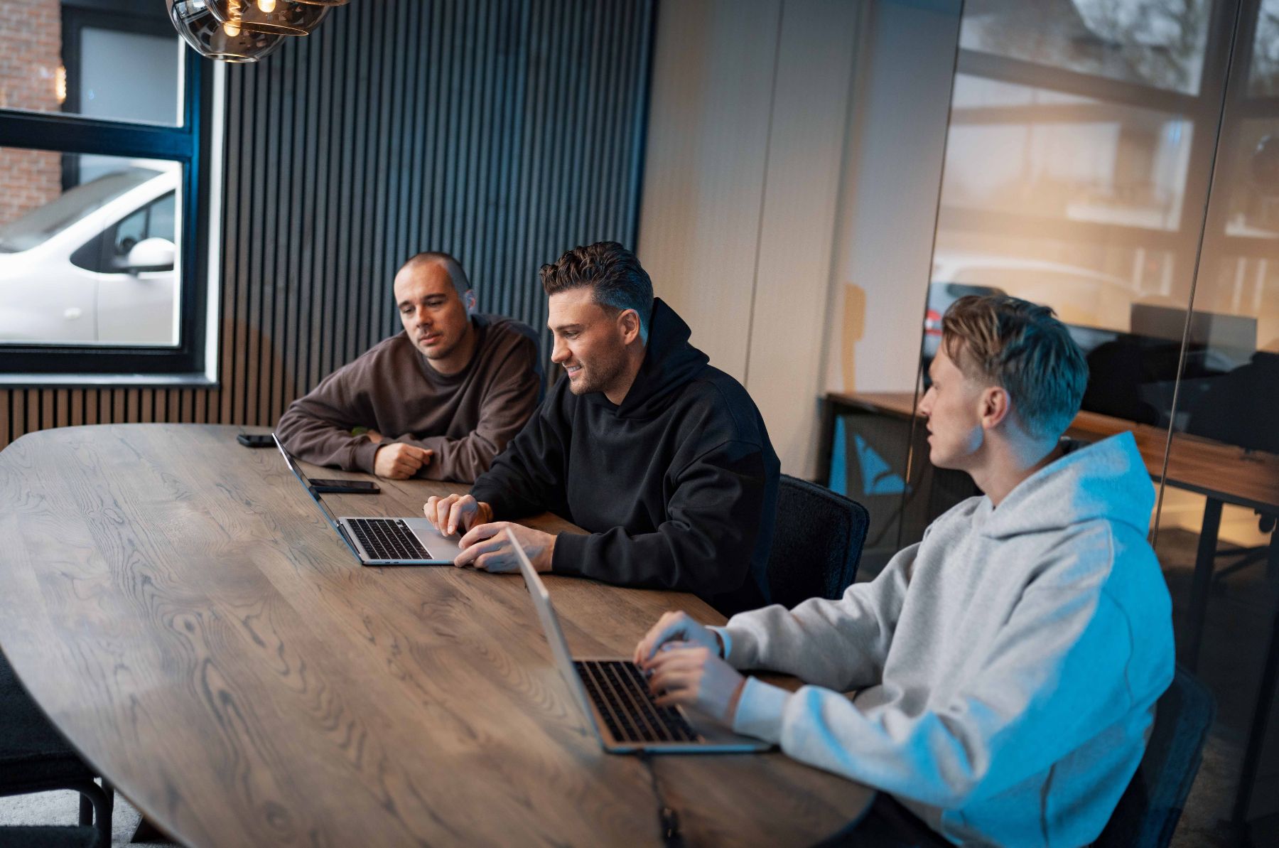 Drie collega’s van Klubb aan de vergadertafel met laptops