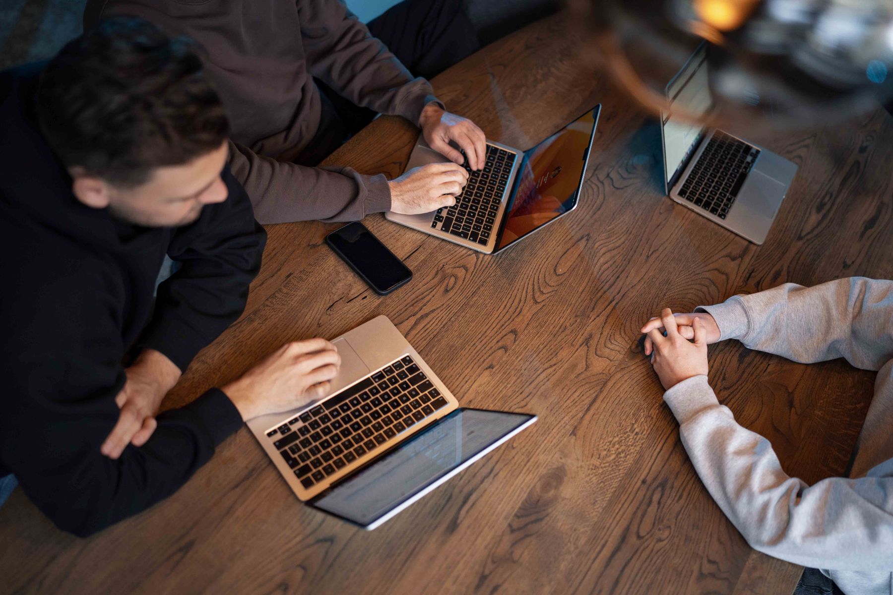 Drie laptops op de vergadertafel van Klubb, van bovenaf